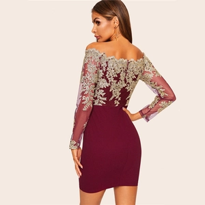 Détail d'une robe de cocktail rouge vin avec broderie en dentelle dorée et manches longues