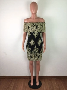 Détail d'une robe élégante à épaules dénudées noire avec broderie paisley dorée complexe