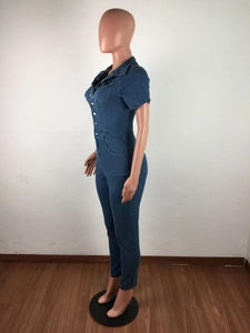 Detail of dark blue denim jumpsuit with metal buttons and chest pockets for women