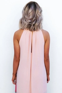 Détail de la robe en mousseline rose pêche montrant le dos en V et la texture plissée