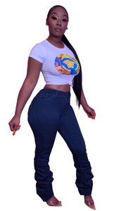 Détail d'un jean skinny taille haute bleu foncé avec un design de jambes plissées tendance