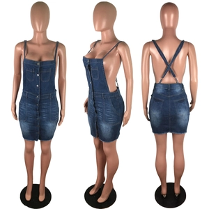 Detail view of denim sundress showing washed texture, buttons, and criss-cross back straps