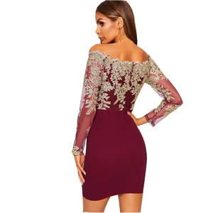 Détail de la robe bordeaux à épaules dénudées avec broderie florale dorée complexe