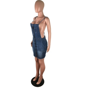 Detail of blue denim pinafore dress showing silver buttons and adjustable thin straps