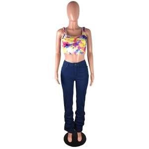 Détail du pantalon en jean bleu taille haute avec effet froncé et empilé sur le bas
