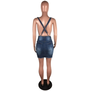 Back view of a sexy halter denim mini dress with cross-straps and vintage washed pockets