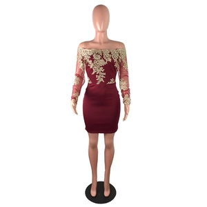 Détail de robe de soirée bordeaux avec broderie dorée complexe et épaules dénudées