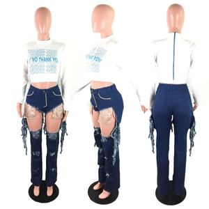 Detail of high waist ripped jeans with sequin pocket lining and distressed fringes