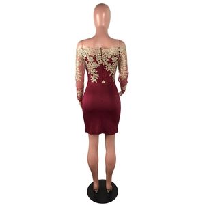 Détail de la broderie florale dorée et du zip arrière de cette robe dentelle rouge vin