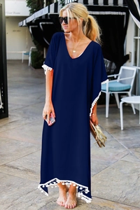 Détail du col en V avec bordure pompon blanc sur robe de plage en mousseline marine