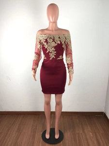 Détails de broderie florale dorée sur les manches en tulle bordeaux de la robe