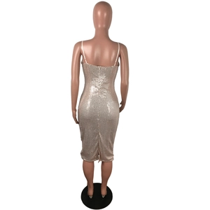 Detail of champagne gold sequin midi dress showing back zipper and hem slit on mannequin