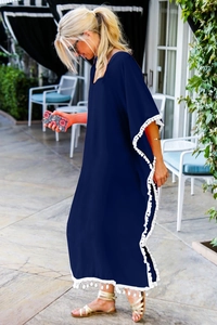Robe de plage bleu marine ample avec franges à pompons blancs et col en V sur terrasse