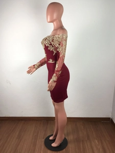 Détail de la robe courte bordeaux à épaules dénudées avec dentelle dorée et manches transparentes