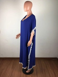 Vue détaillée du caftan bleu roi avec bordure à pompons blancs et col en V