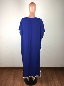 Détail du cache-maillot bleu roi en mousseline avec finitions à pompons blancs