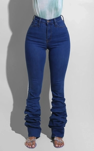 Détail du jean slim taille haute bleu avec design unique de jambes froncées et empilées