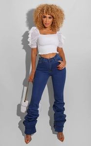 Détail du jean bleu taille haute à effet froncé pour femme avec texture de jambe empilée