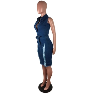 Détail de la robe en jean bleue avec ourlet effiloché et ceinture à la taille