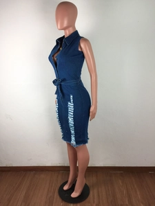 Détails d'une robe en jean avec bords effilochés et textures déchirées sur denim bleu foncé