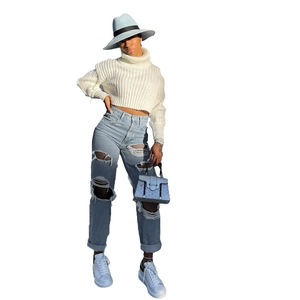Set donna con crop top in maglia bianca e jeans blu chiaro con grandi strappi