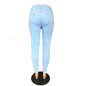 Détail d'un jean skinny taille haute bleu clair avec ourlets effilochés et poches arrière