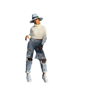 Jeans dritti da donna azzurri con strappi abbinati a un maglione bianco a trecce