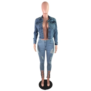 Detail of light blue denim jacket featuring frayed edges and vintage distressed texture