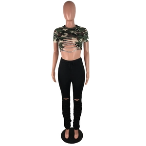 Détail du crop top camouflage à déchirures et leggings noirs froncés sur un mannequin de mode