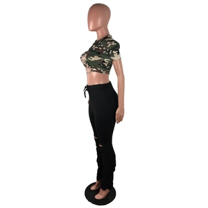 Détail montrant le legging noir à taille haute avec jambes froncées et genou fendu