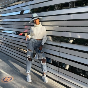 Scatto street style di jeans a gamba larga celesti strappati con sneaker bianche con plateau