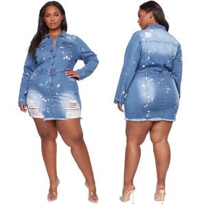 Detail of plus size denim dress with white ink splash and frayed hemline details