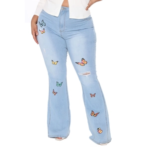Détails de broderies papillons colorés et finitions usées sur ce jean évasé bleu clair