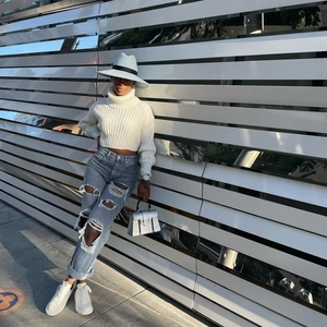 Stile street fashion con jeans a gamba dritta strappati azzurri e scarpe da ginnastica bianche