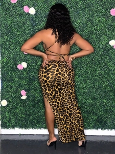 Detail of a leopard print two-piece set featuring an open back top and high slit skirt
