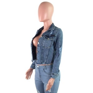 Detailed view of dark blue cropped denim jacket with distressed fringe and metal buttons
