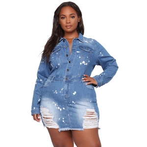 Detail view of denim dress featuring white paint splatter and distressed frayed hemline