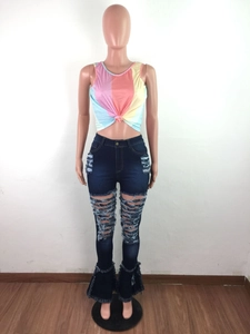 Detail of high-waisted flared jeans featuring heavy distressed rips and fringe hems
