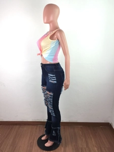 Detail of high-waisted distressed denim jeans with frayed ruffles and vintage wash finish