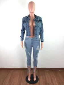 Detail of distressed denim jacket with frayed hems and ripped skinny jeans with lace-up cuffs