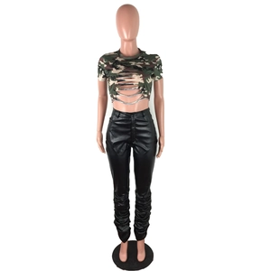 Detail von Camouflage-Crop-Top mit Cut-outs und schwarzer Leggings aus Kunstleder in Stapeloptik