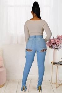 Détail du jean denim bleu clair avec déchirures aux poches et ourlets effilochés stylés
