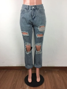 Dettaglio di jeans a vita alta lavaggio azzurro con strappi pesanti e orlo arrotolato alla base