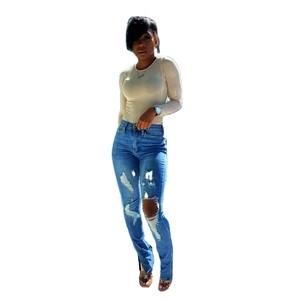 Dames set met blauwe skinny jeans met gaten en zijsplit en beige top met lange mouwen