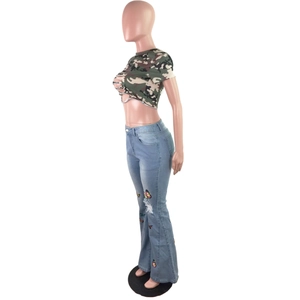 Détail de la broderie papillon et des déchirures sur le jean évasé bleu clair à la mode