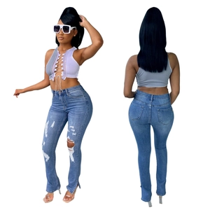 Detail van high waist jeans met scheuren en franje-split met vetersluiting crop top