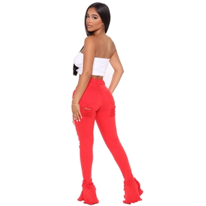 Red high-waisted distressed bell bottom jeans with frayed ruffled hems and ripped details