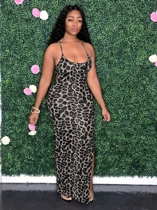 Detail of slim fit leopard print maxi dress with spaghetti straps on floral backdrop