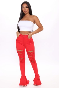 Close-up of distressed ripped details and raw hem on red high-waist flare jeans