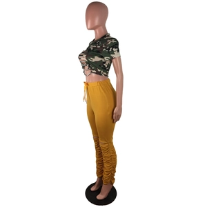 Détail du pantalon plissé jaune moutarde avec cordon de serrage et effet empilé